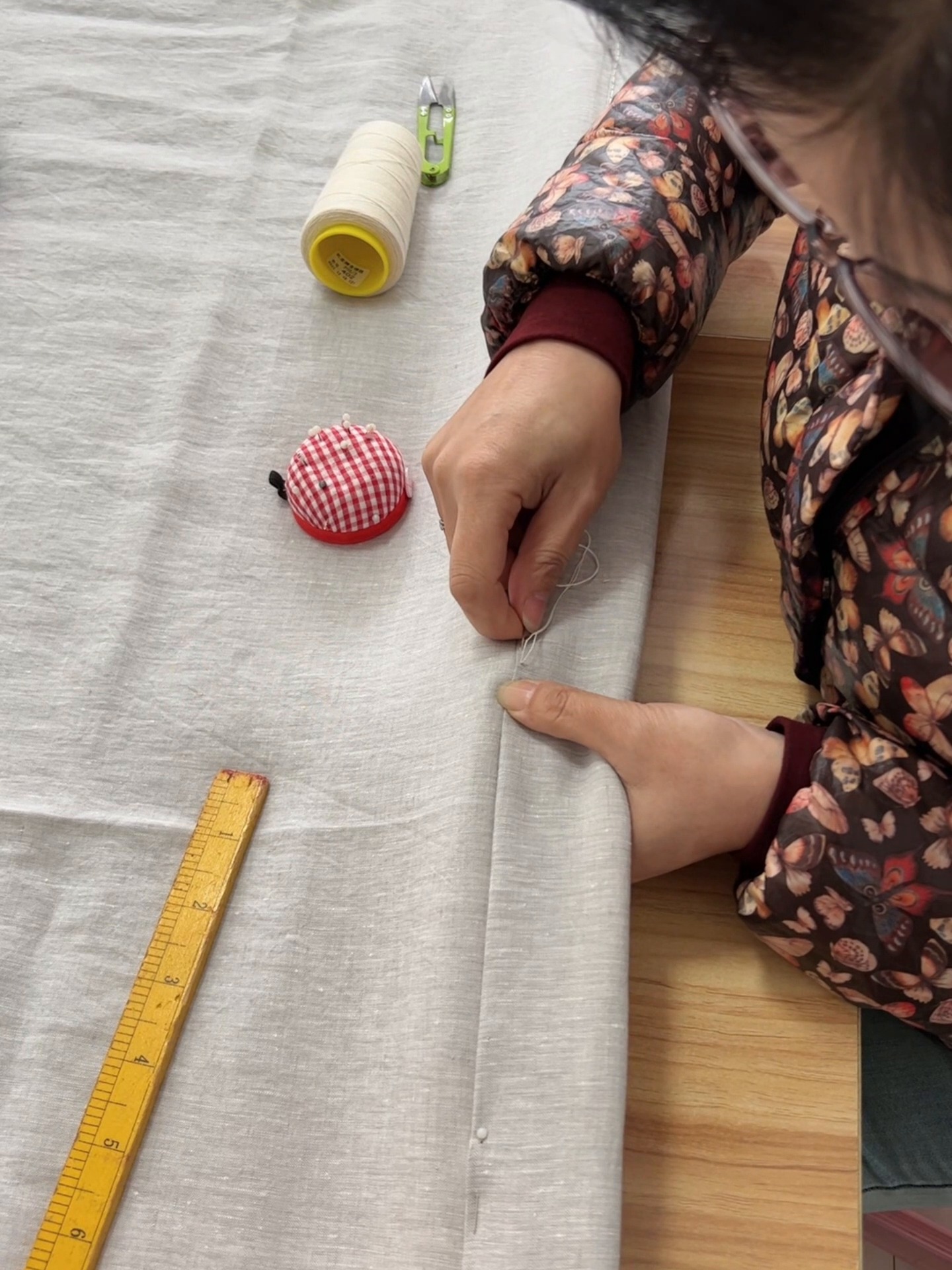 Close view of hand stitching on a linen quilt, photographed during the real making process
